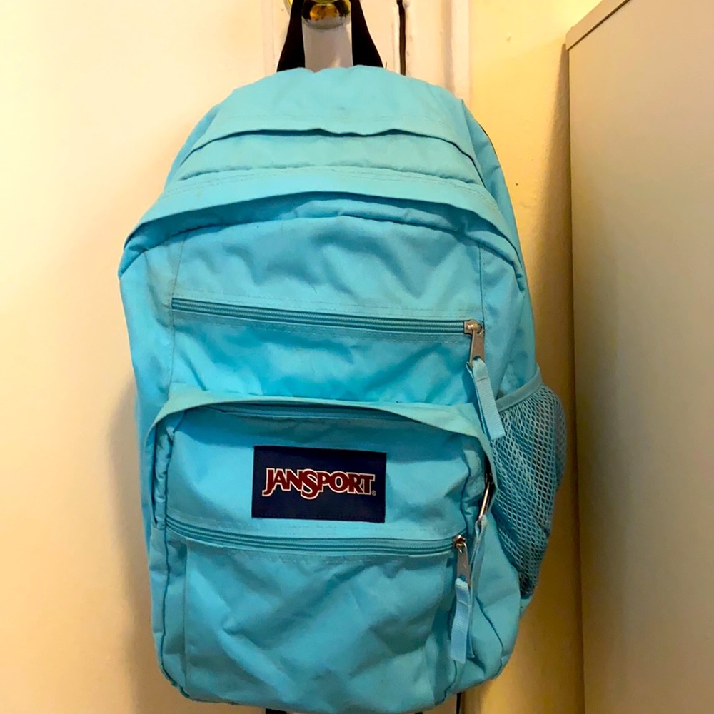 A teal jansport backpack with 5 pockets.